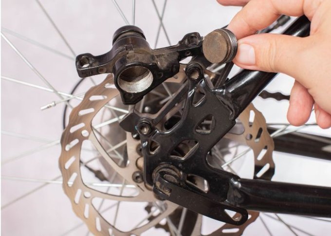 Mężczyzna wymienia klocki hamulcowe w rowerze
